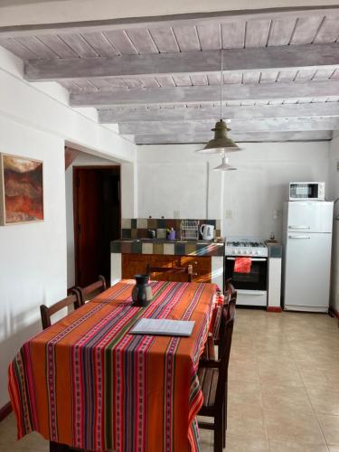 a kitchen with a table and chairs in a room at Cabañas La Sorpresa in Tilcara