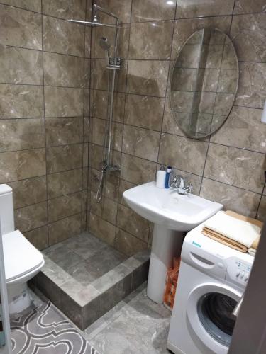 a bathroom with a shower and a sink and a washing machine at TOP view Apartment Budva in Budva