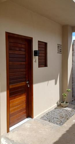 una puerta de madera de una casa con ventana en Pousada Bom gosto, en São Miguel do Gostoso