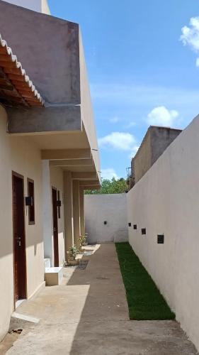 un patio de un edificio con una pared blanca en Pousada Bom gosto, en São Miguel do Gostoso