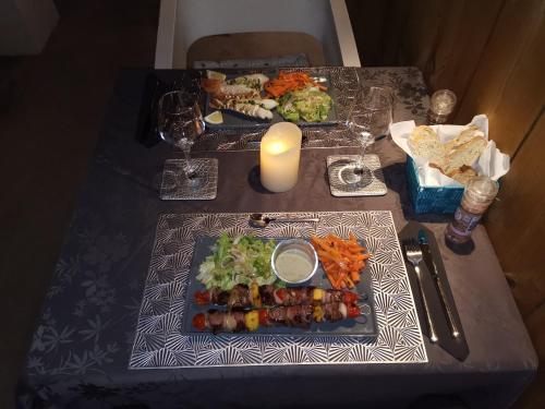 a table with two plates of food and a candle at Hostal 170 Room 16 Service Appartement in Le Tampon
