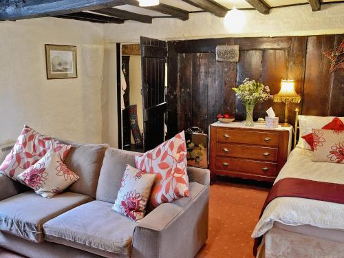 a living room with a couch and a dresser at Barker Knott Farm Cottage in Bowness-on-Windermere