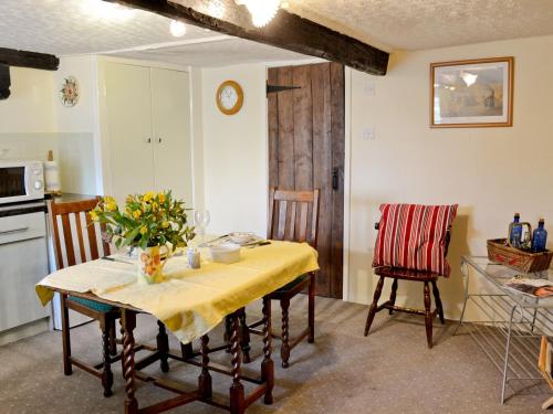 a kitchen and dining room with a table and chairs at Barker Knott Farm Cottage in Bowness-on-Windermere