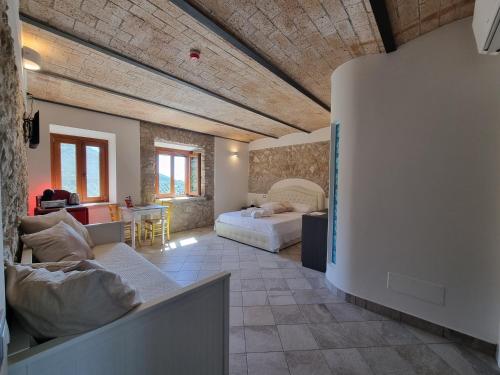 CASALE DEI PRIORI في Rocca Massima: غرفة معيشة مع أريكة وسرير