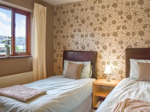 sypialnia z 2 łóżkami i oknem w obiekcie Llican w mieście Llanberis