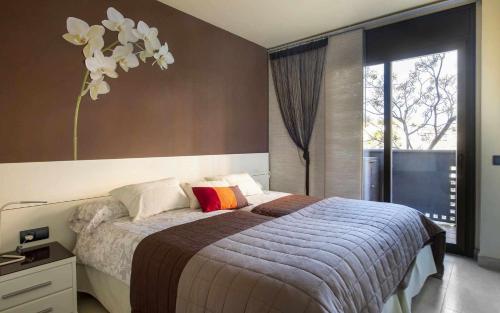 a bedroom with a bed and a large window at Josep Mº Folch Centro in Tossa de Mar