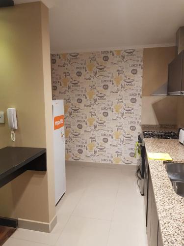 a kitchen with a wall with drawings on it at Departamento Caseros in Salta