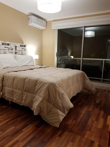a bedroom with a large bed with a large window at Departamento Caseros in Salta