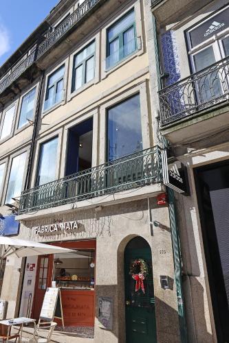 a building with a green door and a balcony at FLH Porto Downtown GuestHouse in Porto