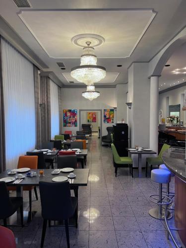a restaurant with tables and chairs and a chandelier at Gästehaus Kral in Erlangen