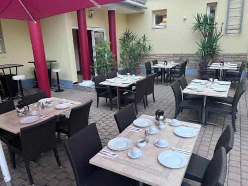 a restaurant with tables and chairs with plates on them at Gästehaus Kral in Erlangen