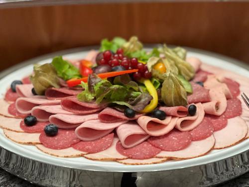 a plate of meat and vegetables on a table at Gästehaus Kral in Erlangen