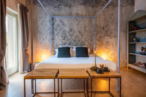 a bedroom with a bed with blue pillows and a table at Langhe Country House in Neive