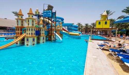a water park in a resort with people laying in chairs at Mirage Bay Resort & Aqua Park in Hurghada
