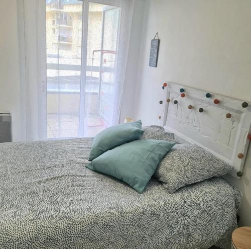 1 dormitorio con 1 cama con cabecera y almohadas en Chez Tifenn en Perros-Guirec