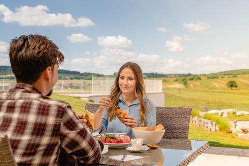 a man and a woman sitting at a table eating food at Gut Leithaberg in Jois