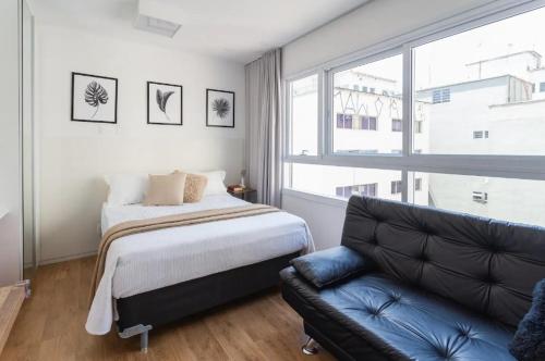 1 dormitorio con cama, sofá y ventana en Studio Aconchegante! 1116, en São Paulo