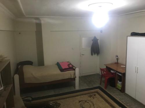 een kleine kamer met een bed en een tafel en een licht bij House in Kayapınar