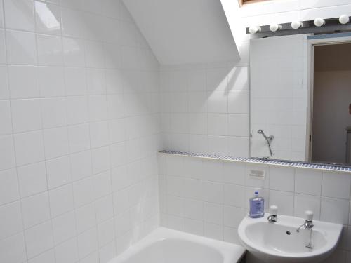 a white bathroom with a sink and a bath tub at Lo-tide in Middleton-on-Sea