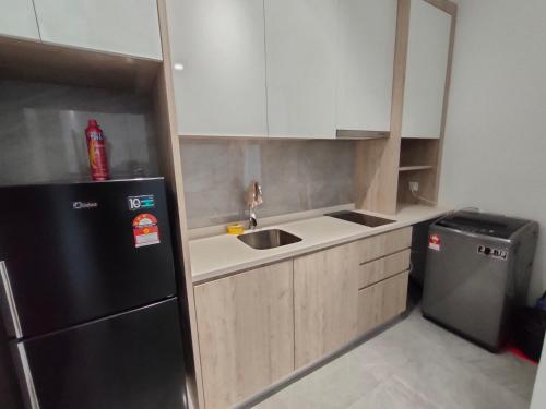 a small kitchen with a sink and a refrigerator at Imperio Residence Bathtub Studio at Malacca Town-Near JONKER STREET in Melaka