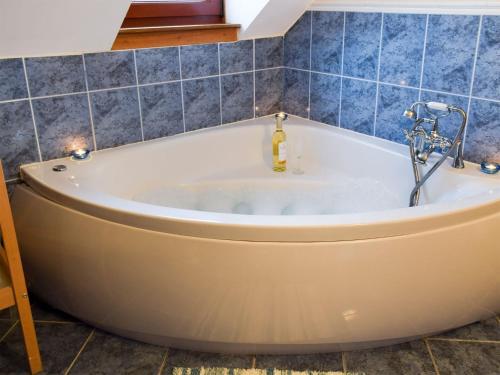 克羅斯蓋茨的住宿－班克黑德農場鄉村別墅，浴室设有浴缸,铺有蓝色瓷砖。