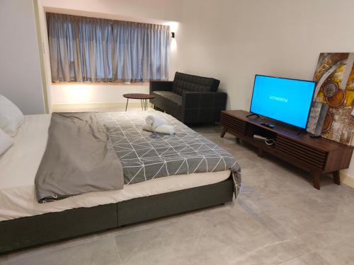 a bedroom with a bed and a flat screen tv at Imperio Residence Bathtub Studio at Malacca Town-Near JONKER STREET in Melaka