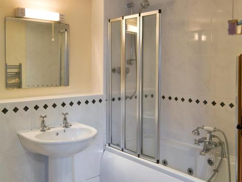 a white bathroom with a sink and a shower at Goose Cottage - Ukc2676 in Poundstock