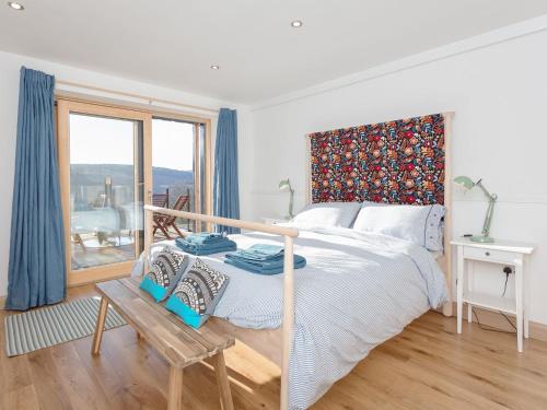 a white bedroom with a bed and a window at Jill Strawbale House- Ukc2935 in Strontian