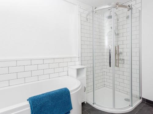 y baño blanco con ducha y bañera. en Jill Strawbale House- Ukc2935 en Strontian