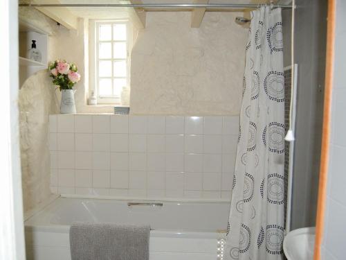 a bathroom with a tub and a shower curtain at Nightingale Cottage - Ukc1570 in Crich