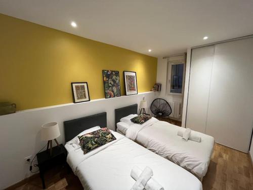 モンペリエにあるLa Comédie, appart de Charmeのベッド2台が備わる客室で、