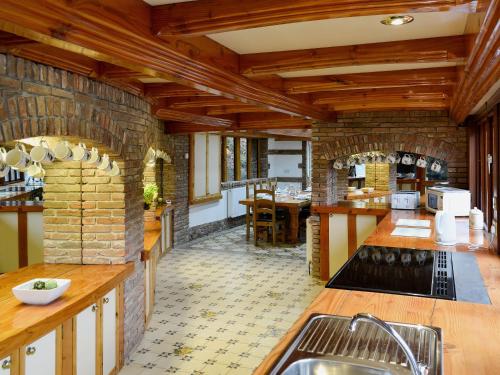 a large kitchen with a stone wall and wooden ceilings at The Farmhouse - Ukc1339 in North Molton