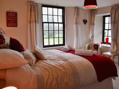 a bedroom with a large bed with two windows at The Farmhouse - Ukc1339 in North Molton