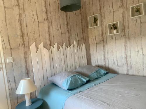 ein Schlafzimmer mit einem Bett mit einer Holzwand in der Unterkunft Chez Mimi in Saint-Germain-sur-Ay