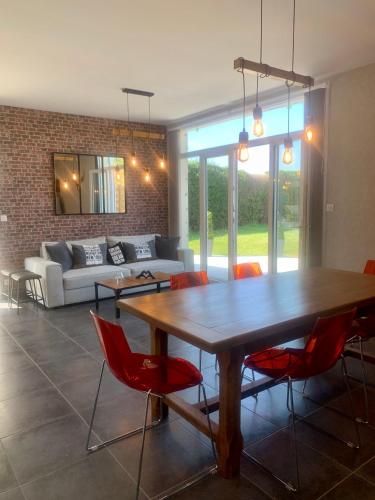 une salle à manger avec une table en bois et des chaises rouges dans l'établissement Chez Mimi, à Saint-Germain-sur-Ay