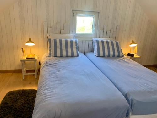 2 große Betten in einem Schlafzimmer mit Fenster in der Unterkunft Chez Mimi in Saint-Germain-sur-Ay
