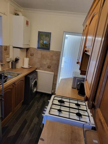 a kitchen with a stove and a sink in it at Homey Bella House in Luton