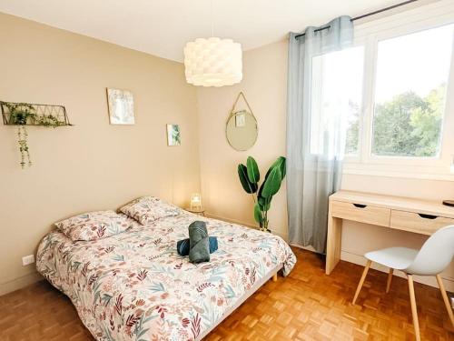 - une chambre avec un lit avec un animal rembourré dans l'établissement Cosy Mûre - 4 CH - Wifi- Parking gratuit, à Pau