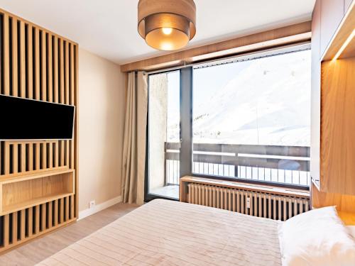 une chambre avec un lit et une grande fenêtre dans l'établissement Apartment Les Hauts du Val Claret - Val Claret-23 by Interhome, à Tignes