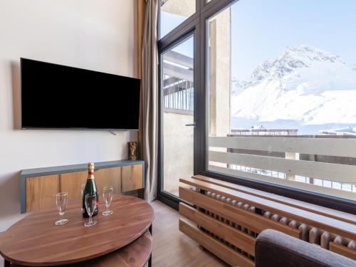 um quarto com uma mesa com copos de vinho e uma grande janela em Apartment Les Hauts du Val Claret - Val Claret-23 by Interhome em Tignes