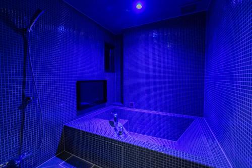 a bathroom with a tub with purple lights in it at Design Hotel W Zip Club in Nagoya