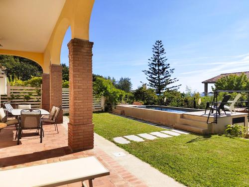 un patio con mesa, sillas y piscina en Cilento Loft with Private Pool, en Ascea