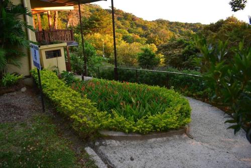 a house with a garden of plants and a walkway at Flower’s Paradise Monteverde in Monteverde Costa Rica