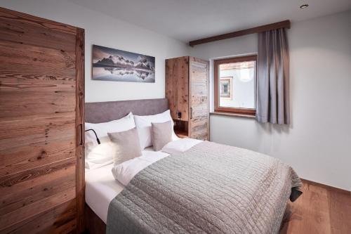 sypialnia z łóżkiem i oknem w obiekcie Alpin Residenzen Buchensteinwand St. Ulrich by Alpina-Holiday w mieście St. Ulrich am Pillersee