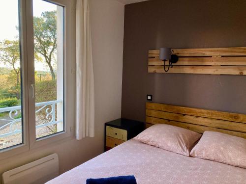 - une chambre avec un lit à côté d'une fenêtre dans l'établissement Les Restanques Glycines 2067, à Grimaud