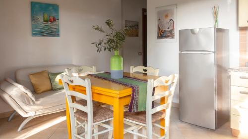 a kitchen with a yellow table and a refrigerator at Welcomely - Sa Perda in Tortolì