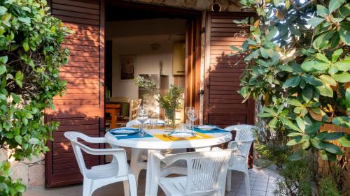 a white table and chairs on a patio at Welcomely - Sa Perda in Tortolì