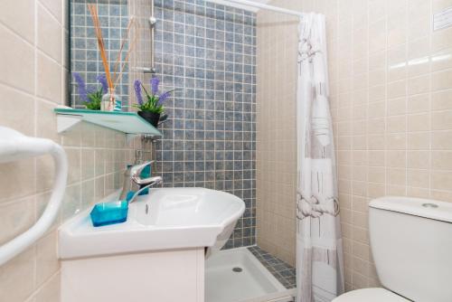a bathroom with a sink and a toilet and a shower at Casa Florinda in Tavira