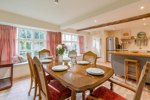 a kitchen and dining room with a table and chairs at Woodmancote Manor Cottage in Cirencester