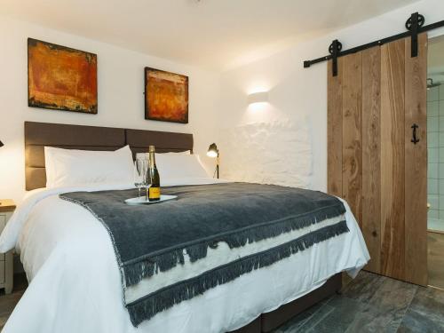 um quarto com uma cama e uma garrafa de vinho em Blakeskerra Barn em Kenfig
